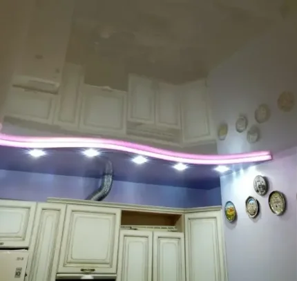 Натяжной глянцевый потолок для кухни со встроенными светильниками и светодиодной подсветкой.